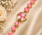 Close-up of pink dial and gold-tone bracelet watch for women with faceted pink accents