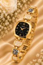 Close-up of gold-tone black dial bracelet watch with cream and grey marbled-look links